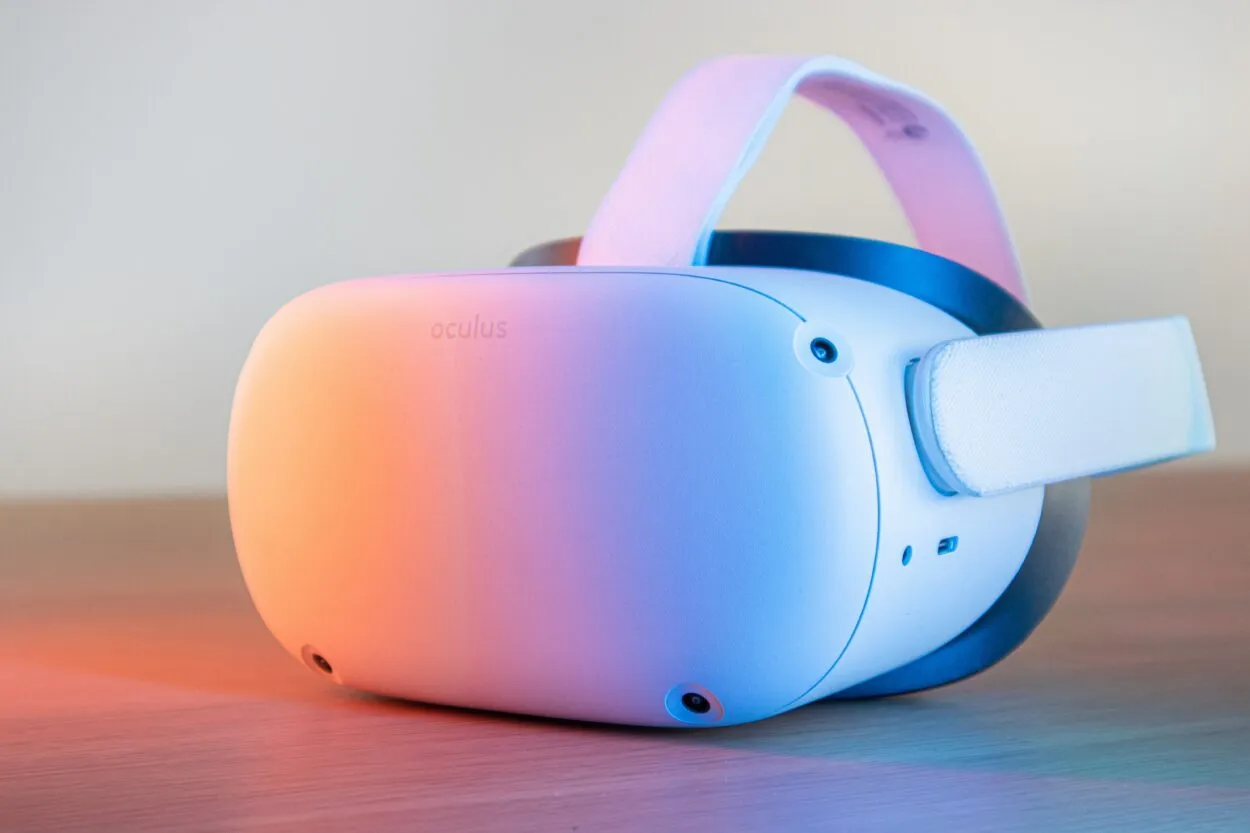Oculus headset i vit färg placerat på en yta med ett rosa färgat ljus på