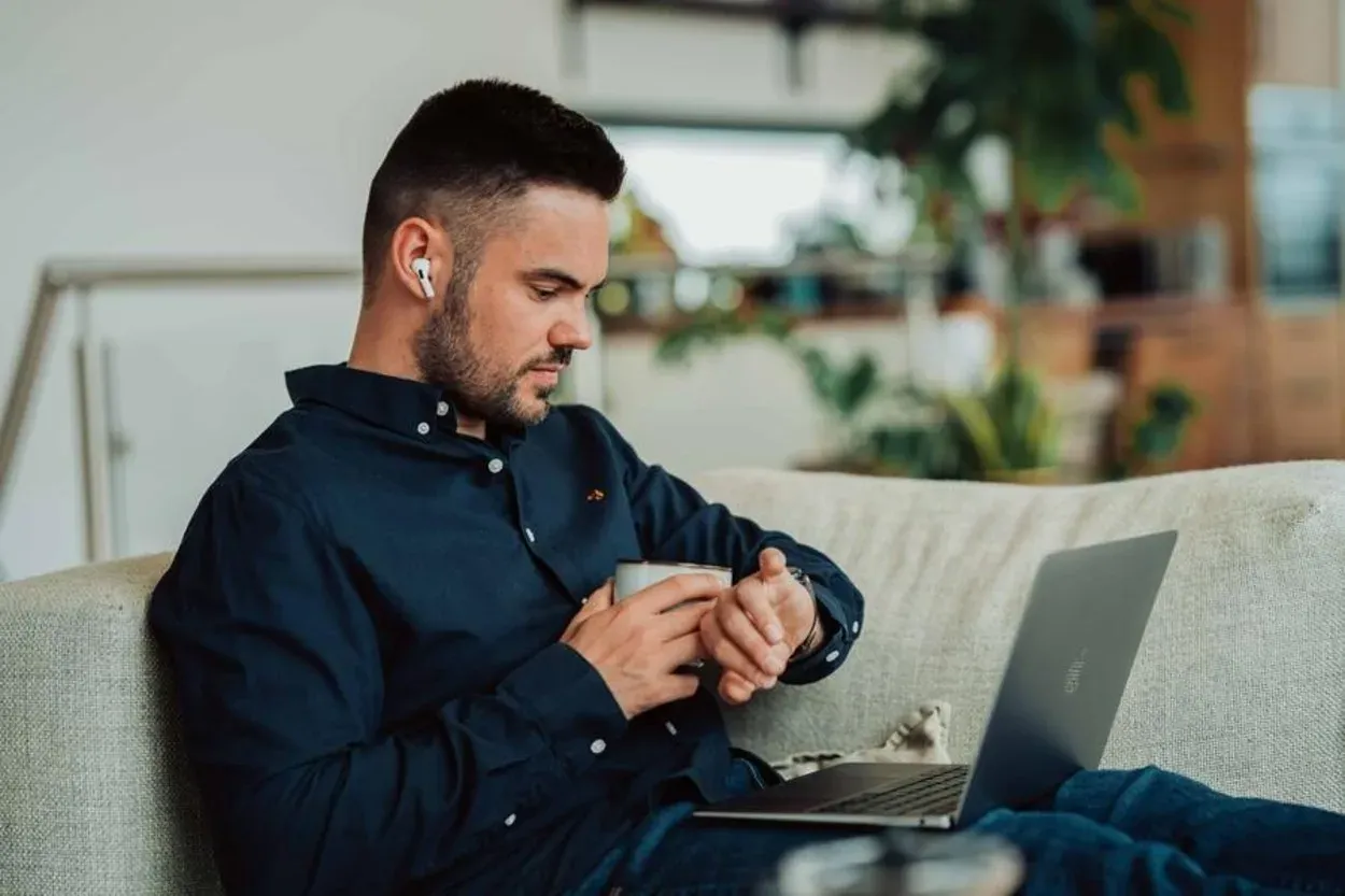 Osoba używająca słuchawek AirPods z komputerem Macbook Pro