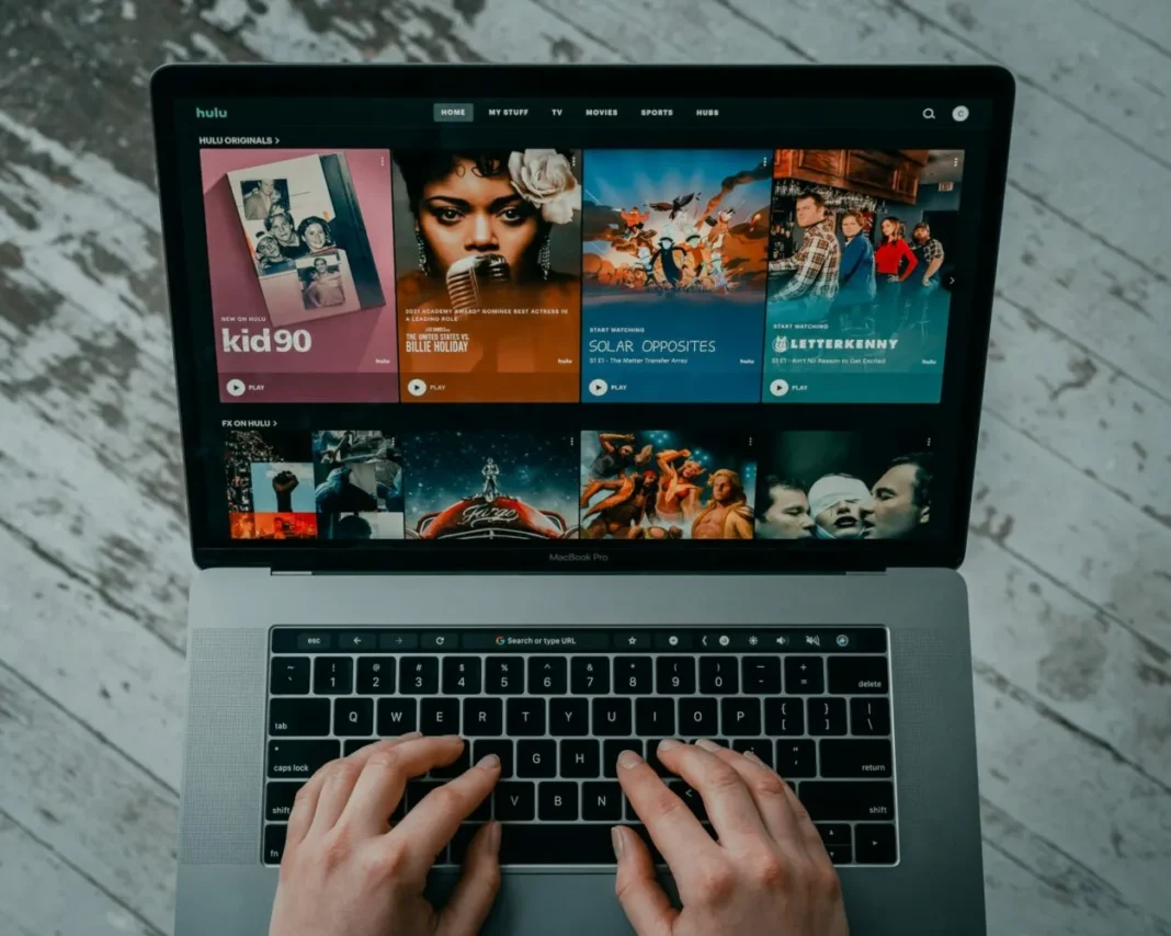 A person using laptop displaying the Home page of Hulu