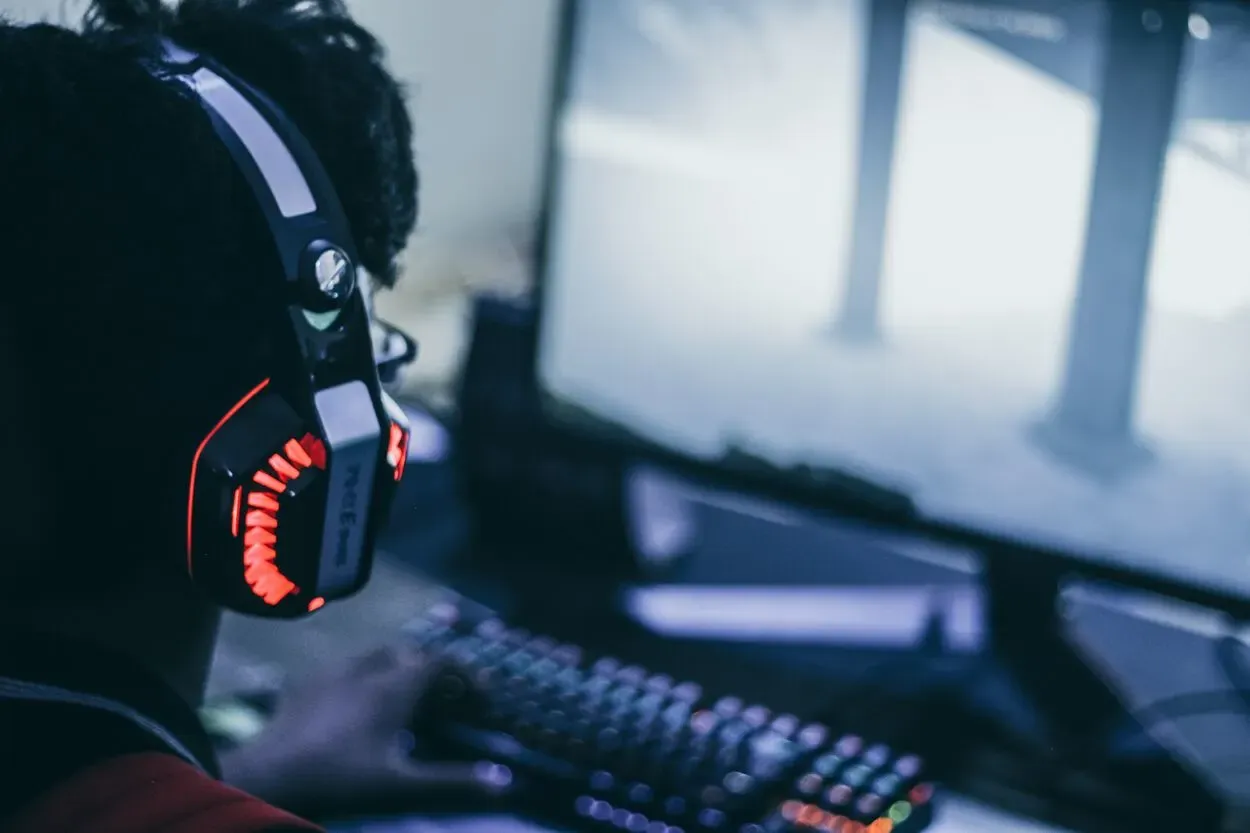 A man playing video games with RGB Headphones on.