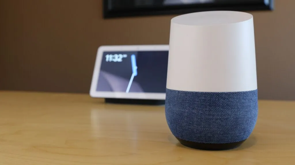 Google Home Hub sitting on desk with Google Home Max in background