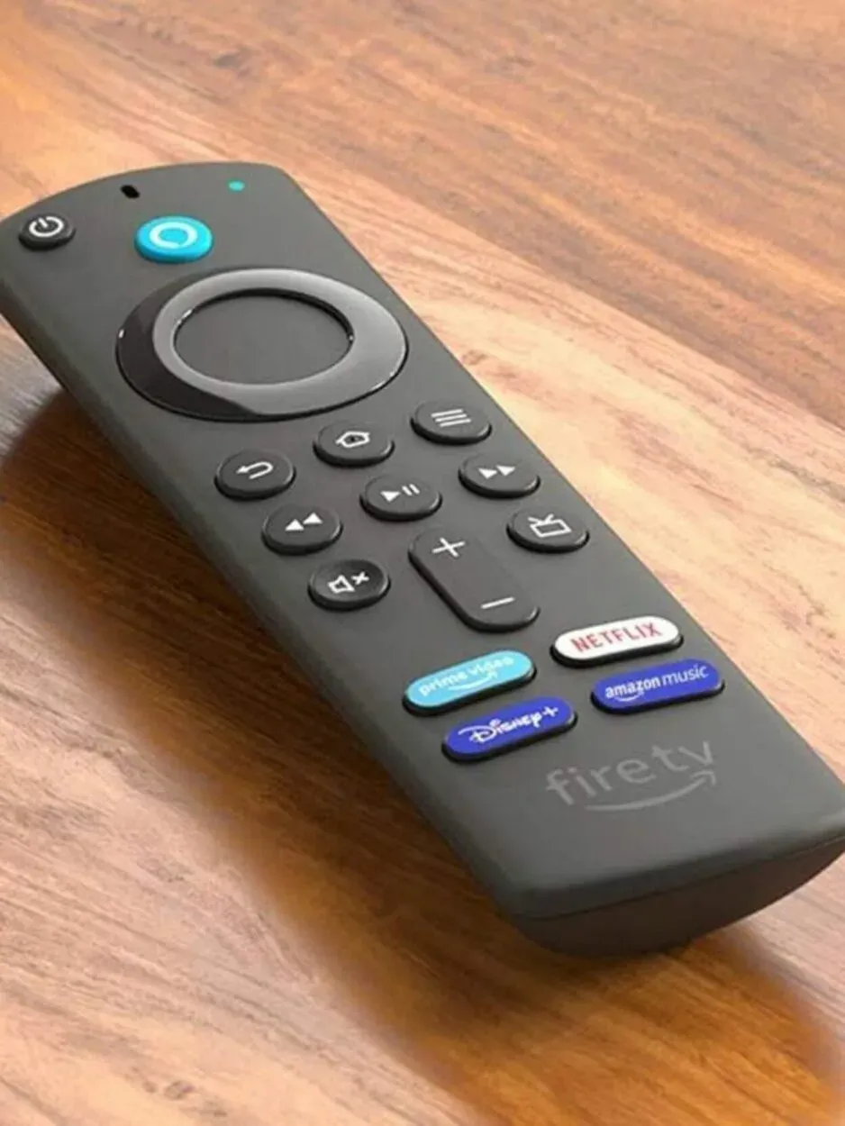 Firetv Black Remote placed on a table with numerous buttons.