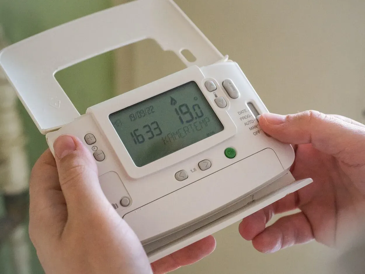 Man controlling wireless thermostat