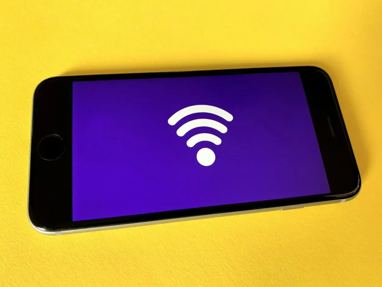 Puhelimessa näkyy Wi-Fi-symboli violetilla taustalla.