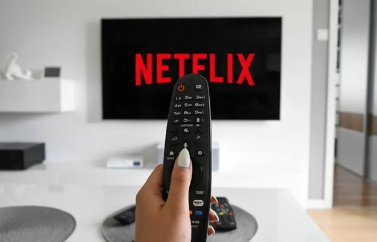 Netflixin logo kaukosäätimen ja television kanssa.